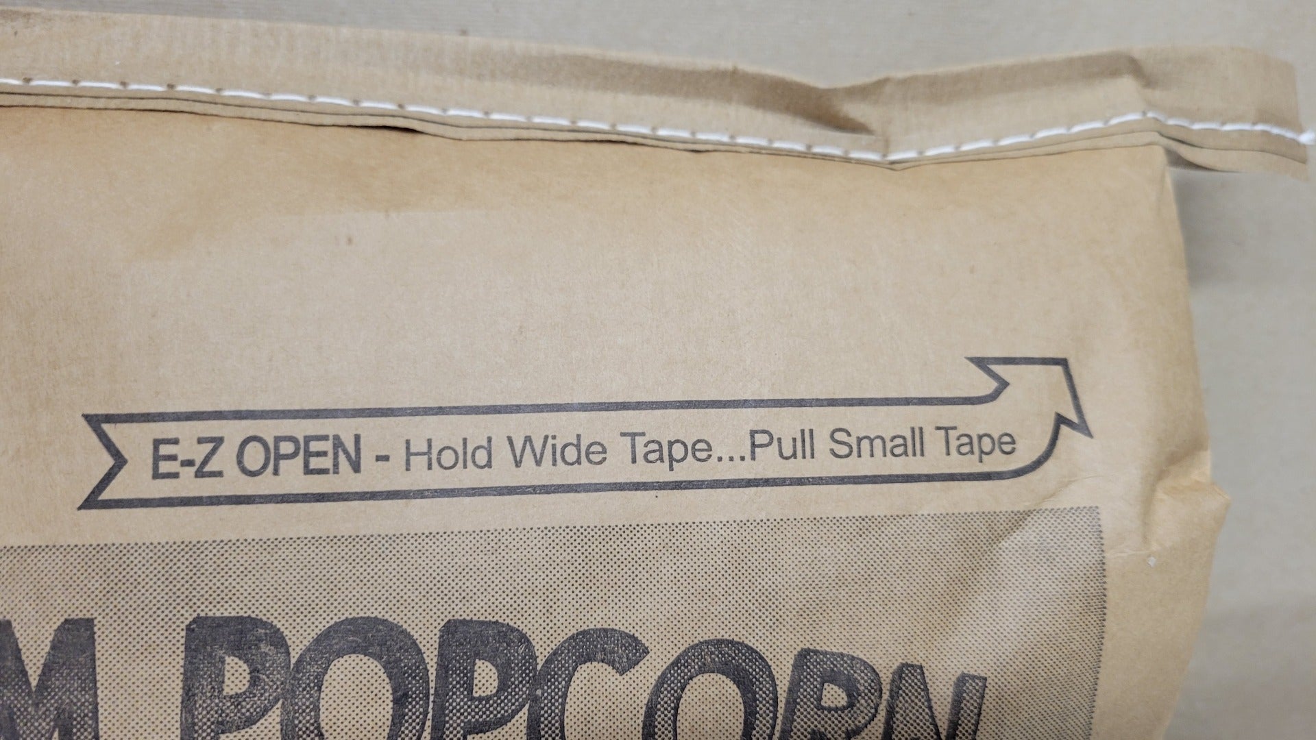 E-Z Open pull tape makes it easy to open the bag. Just grab the small brown strip behind the string and pull.