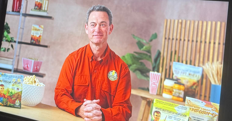 Farmer Bob on the studio monitor during his Amazon interview in Seattle, with Princeton Popcorn bags on the table